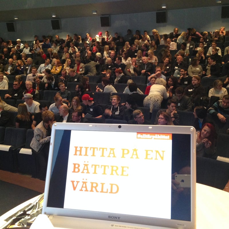 Navid Modiri på scen i en fullsatt aula.