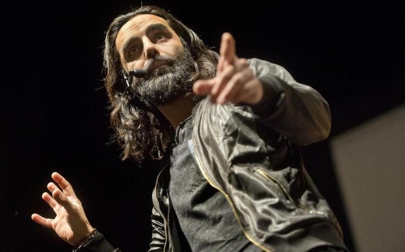 Navid Modiri på scen under en föreläsning.
