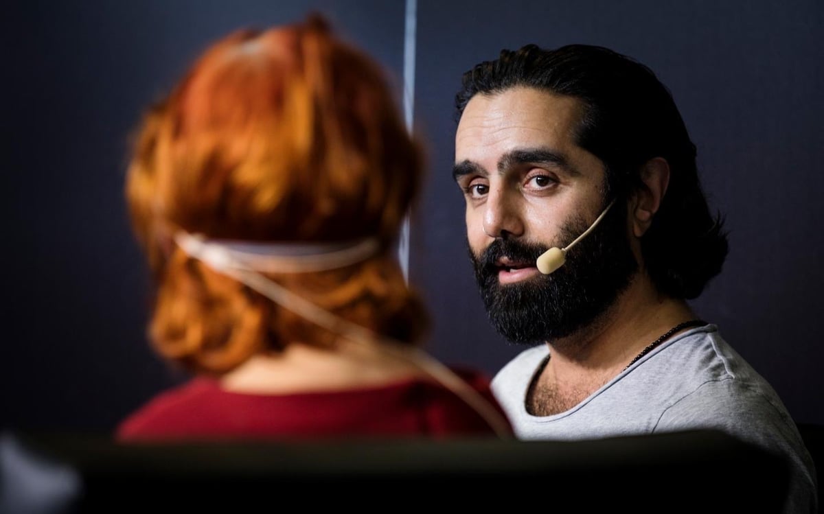Navid Modiri i samtal på scen på Bokmässan, med mikrofon och en samtalspartner.